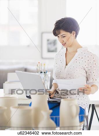 Portrait of woman in art studio using laptop View Large Photo Image Stock Image - Portrait of woman in art studio using laptop. Fotosearch