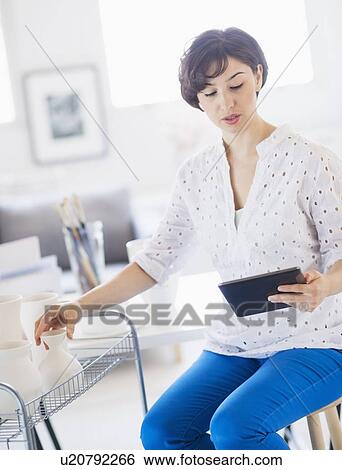 Portrait of woman in art studio using digital tablet View Large Photo Image Stock Photograph - Portrait of woman in art studio using digital tablet. Fotosearch