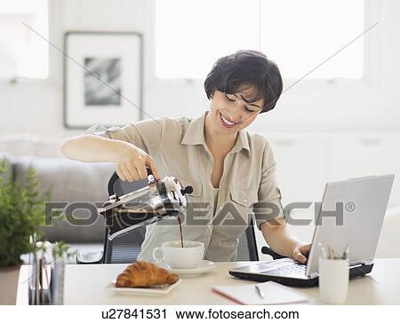 Portrait of woman pouring coffee in front of laptop View Large Photo Image Stock Image - Portrait of woman pouring coffee in front of laptop. Fotosearch