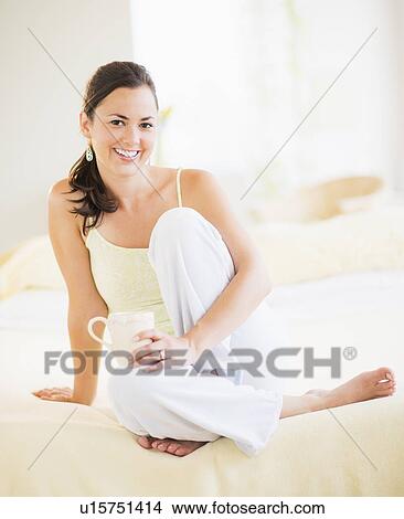 Picture - Portrait of woman relaxing in bedroom. Fotosearch