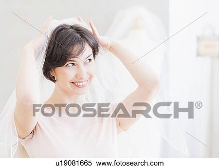 Portrait of woman trying on wedding veil View Large Photo Image Stock Photography - Portrait of woman trying on wedding veil. Fotosearch