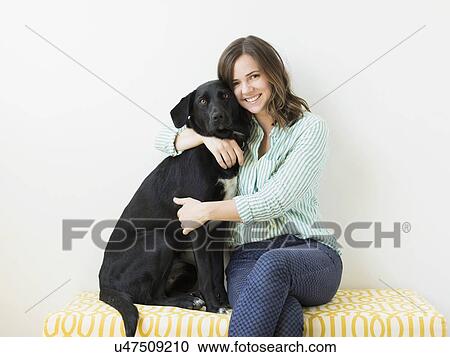 Stock Image - Portrait of woman with black dog. Fotosearch