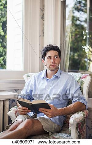 Portrait of young man relaxing with book View Large Photo Image Stock Image - Portrait of young man relaxing with book. Fotosearch