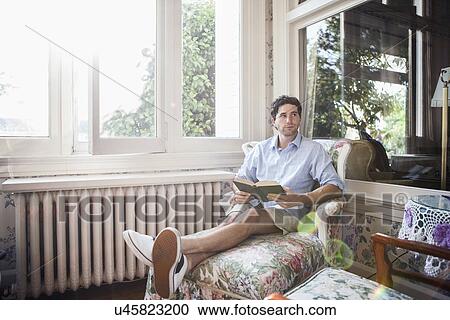 Portrait of young man relaxing with book View Large Photo Image Stock Image - Portrait of young man relaxing with book. Fotosearch