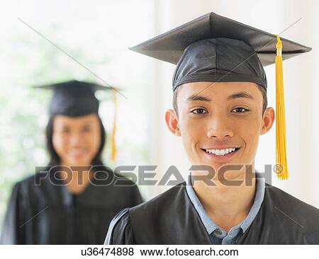 Portrait of young woman and young man wearing graduation gown View Large Photo Image Stock Photo - Portrait of young woman and young man wearing graduation gown. Fotosearch