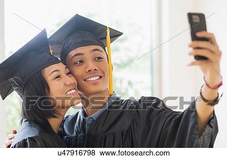 Portrait of young woman and young man wearing graduation gown View Large Photo Image Stock Photo - Portrait of young woman and young man wearing graduation gown. Fotosearch