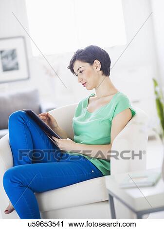 Portrait of young woman using digital tablet at home View Large Photo Image Stock Image - Portrait of young woman using digital tablet at home. Fotosearch