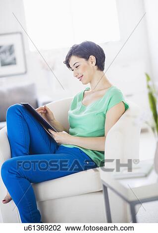 Portrait of young woman using digital tablet at home View Large Photo Image Stock Image - Portrait of young woman using digital tablet at home. Fotosearch