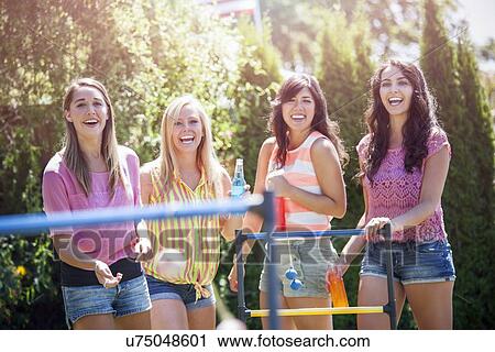 Stock Image - Portrait of young women throwing balls. Fotosearch