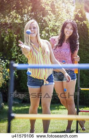 Stock Photograph - Portrait of young women throwing balls. Fotosearch