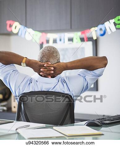 Rear view of man in office, congratulations sign in background View Large Photo Image Stock Photograph - Rear view of man in office, congratulations sign in background. Fotosearch
