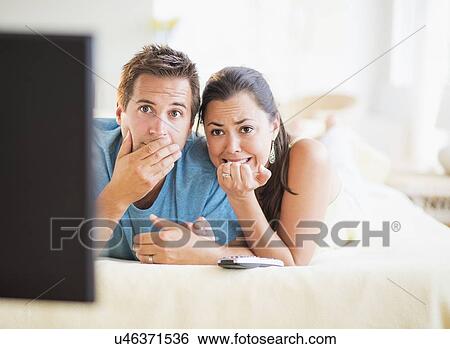 Scared couple watching TV View Large Photo Image Stock Photograph - Scared couple watching TV. Fotosearch