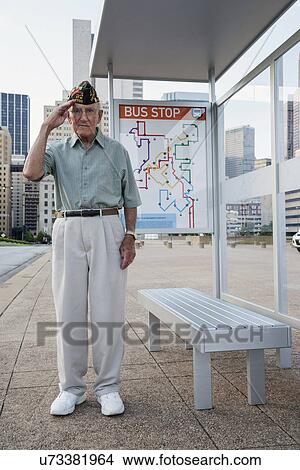 Senior man standing and saluting at bus stop View Large Photo Image Picture - Senior man standing and saluting at bus stop. Fotosearch