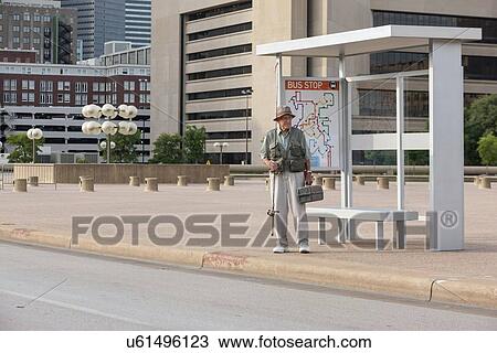Senior man standing at bus stop with fishing rod View Large Photo Image Stock Image - Senior man standing at bus stop with fishing rod. Fotosearch