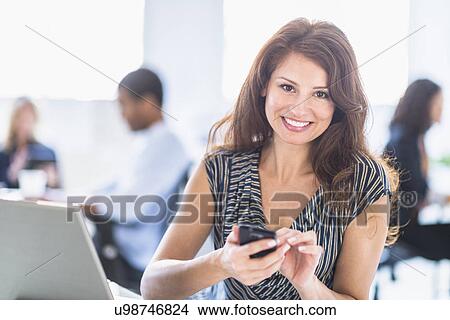 Picture - Smiling woman in office. Fotosearch