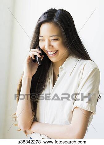 Smiling young woman talking via mobile phone View Large Photo Image Stock Photo - Smiling young woman talking via mobile phone. Fotosearch