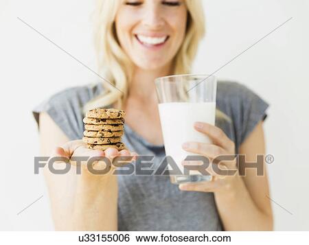 Studio portrait of blonde woman holding glass of milk and cookies View Large Photo Image Stock Photograph - Studio portrait of blonde woman holding glass of milk and cookies. Fotosearch