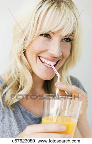Studio portrait of blonde woman drinking orange juice View Large Photo Image Stock Image - Studio portrait of blonde woman drinking orange juice. Fotosearch