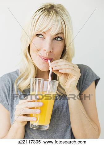 Studio portrait of blonde woman drinking orange juice View Large Photo Image Stock Photography - Studio portrait of blonde woman drinking orange juice. Fotosearch
