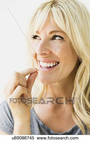 Stock Photography - Studio portrait of blonde woman taking pill. Fotosearch