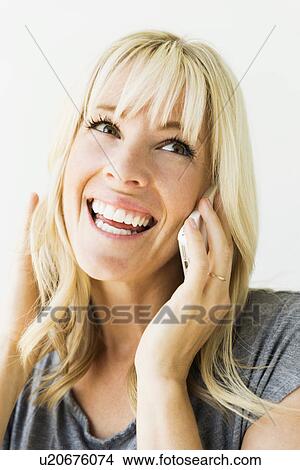 Studio portrait of blonde woman talking on mobile View Large Photo Image Picture - Studio portrait of blonde woman talking on mobile. Fotosearch