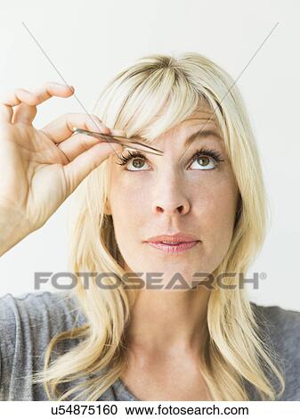 Studio portrait of blonde woman with tweezers View Large Photo Image Stock Image - Studio portrait of blonde woman with tweezers. Fotosearch