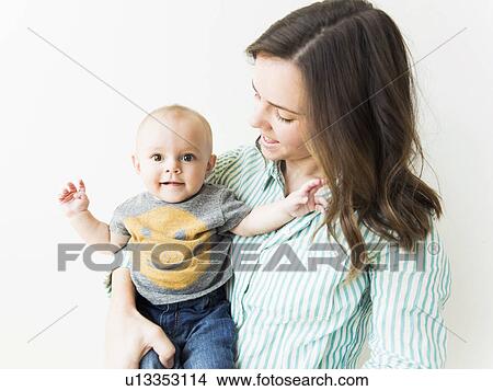 Studio portrait of mother holding baby boy (6-11 months) View Large Photo Image Picture - Studio portrait of mother holding baby boy (6-11 months). Fotosearch