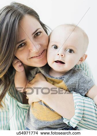 Picture - Studio portrait of mother holding baby boy (6-11 months). Fotosearch