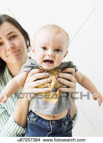 Studio portrait of mother holding baby boy (6-11 months) View Large Photo Image Picture - Studio portrait of mother holding baby boy (6-11 months). Fotosearch