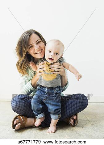 Stock Photo - Studio portrait of mother holding baby boy (6-11 months). Fotosearch