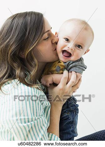 Studio portrait of mother holding baby boy (6-11 months) View Large Photo Image Stock Photograph - Studio portrait of mother holding baby boy (6-11 months). Fotosearch