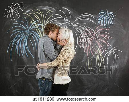 Studio portrait of young couple embracing in front of blackboard View Large Photo Image Stock Photograph - Studio portrait of young couple embracing in front of blackboard. Fotosearch