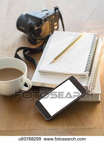 Stock Photo - Studio shot of notepads, smartphone, camera and coffee. Fotosearch