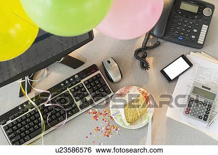 Stock Photograph - Studio shot of office workspace with cake and balloons. Fotosearch