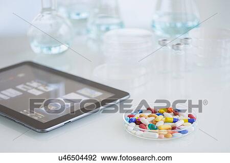 Stock Image - Studio shot of tablet pc and colorful pills. Fotosearch