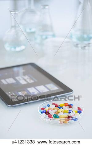 Stock Photo - Studio shot of tablet pc and colorful pills. Fotosearch