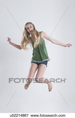 Stock Photo - Studio Shot of teenage girl (14-15) jumping. Fotosearch