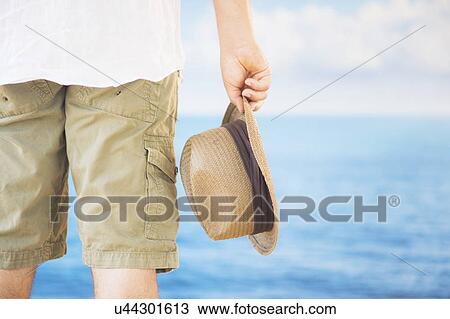 Studio Shot Rear view of man holding straw hat View Large Photo Image Stock Image - Studio Shot Rear view of man holding straw hat. Fotosearch