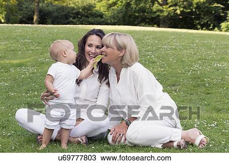 Stock Image - Three generation family playing in park. Fotosearch