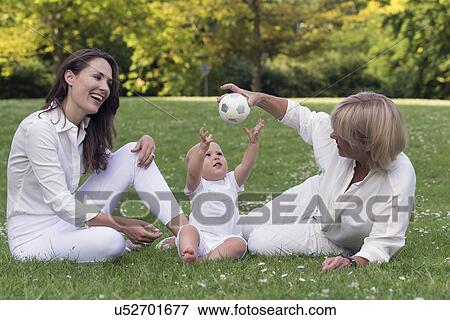 Three generation family playing in park View Large Photo Image Stock Photo - Three generation family playing in park. Fotosearch