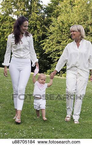 Three generation family walking in park View Large Photo Image Picture - Three generation family walking in park. Fotosearch