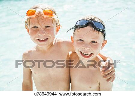 Two boys (4-5) playing in swimming pool View Large Photo Image Picture - Two boys (4-5) playing in swimming pool. Fotosearch