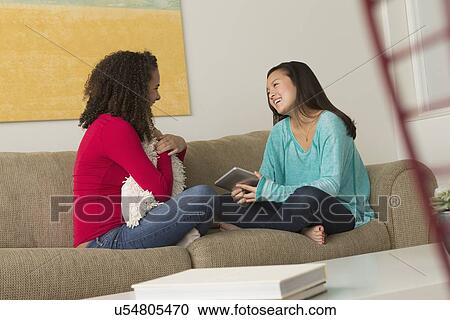 Two friends (12-13, 16-17) sitting on sofa View Large Photo Image Stock Image - Two friends (12-13, 16-17) sitting on sofa. Fotosearch