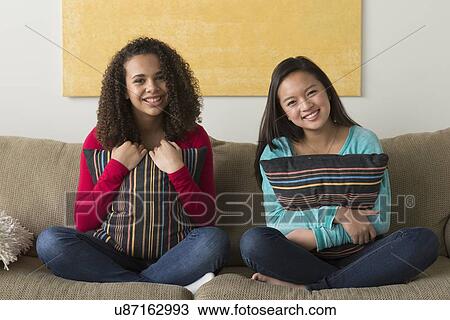 Two friends (12-13, 16-17) sitting on sofa View Large Photo Image Stock Image - Two friends (12-13, 16-17) sitting on sofa. Fotosearch