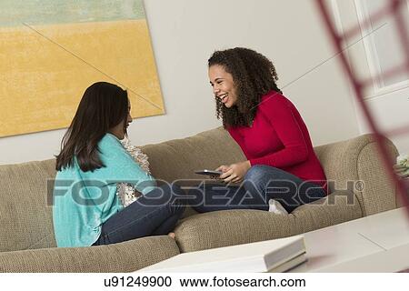 Two friends (12-13, 16-17) sitting on sofa View Large Photo Image Stock Image - Two friends (12-13, 16-17) sitting on sofa. Fotosearch