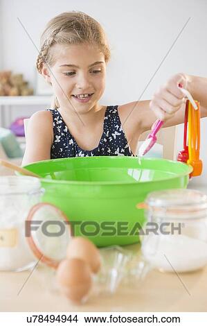 Picture - View of girl (8-9) baking. Fotosearch