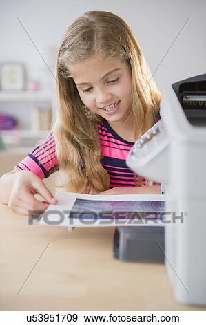 Stock Photo - View of girl (8-9) printing photo. Fotosearch