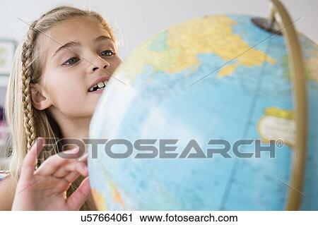 Stock Image - View of girl (8-9) with globe. Fotosearch