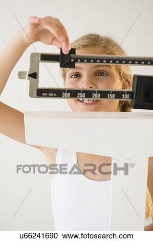 View of girl (8-9) with weight scale View Large Photo Image Stock Image - View of girl (8-9) with weight scale. Fotosearch