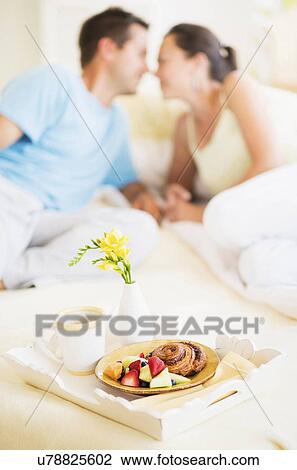 Stock Image - Woman and man having breakfast in bed. Fotosearch